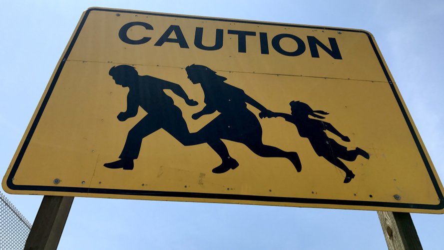 la-me-immigrants-running-road-sign-20170614.jpg