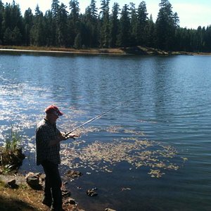 Dad taking a break from hunting , looking for a trout