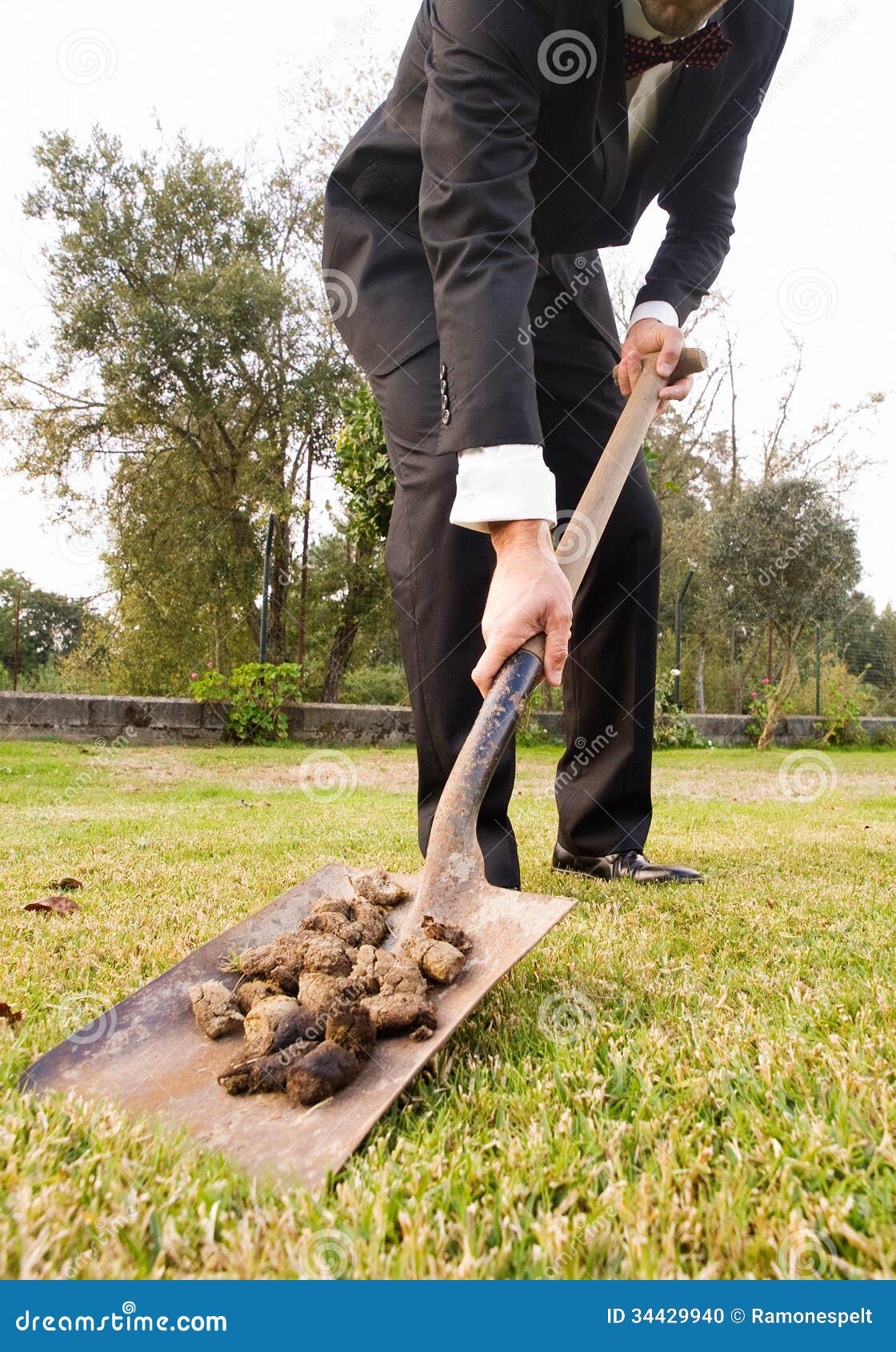 businessman-picking-up-droppings-shovel-outdoors-34429940.jpg